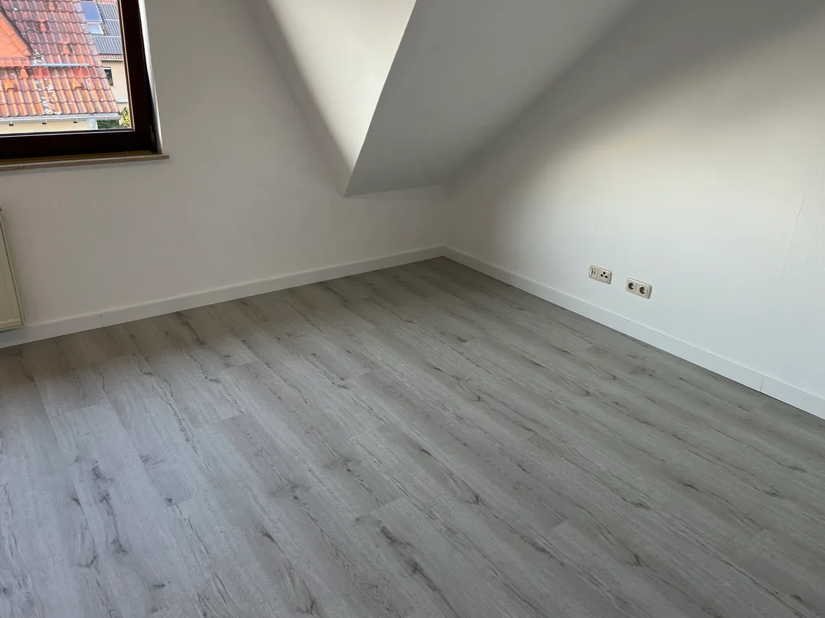 Zimmer mit Fenster und Dachschräge, Boden aus hellem Klick-Vinyl