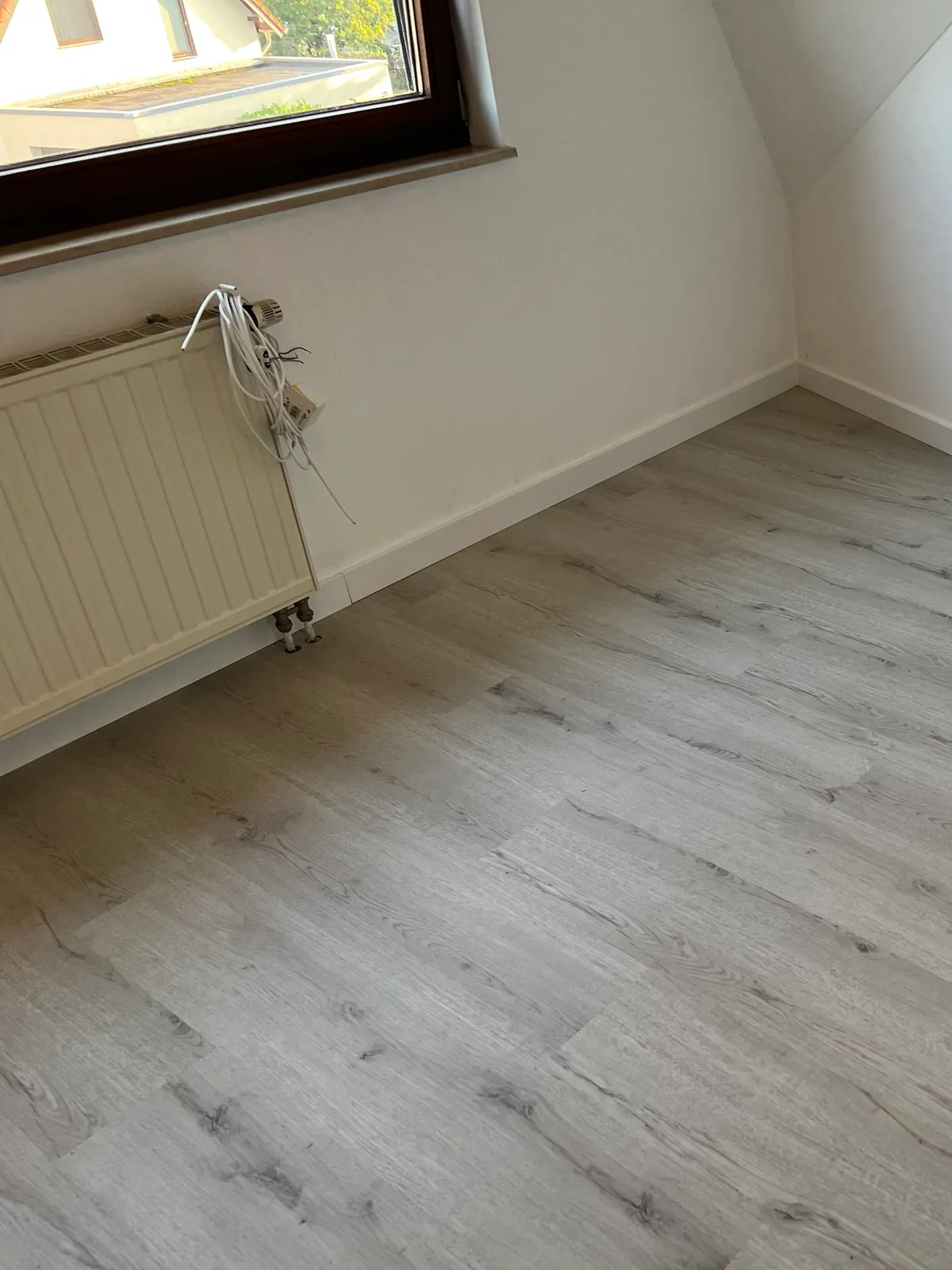 Dasselbe Zimmer nachher mit hellem Klick-Vinyl und Sockelleisten