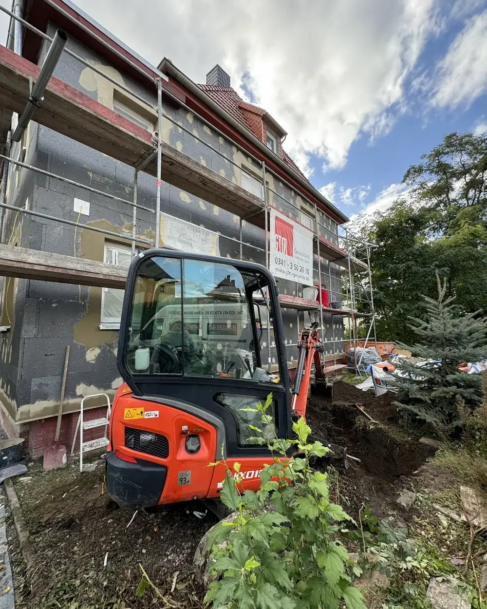Minibagger vor einem Haus beim Rückbau